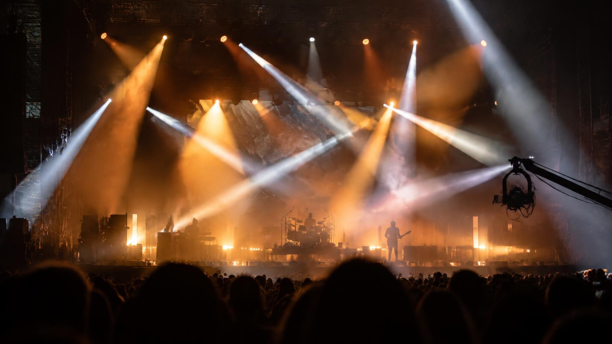 Live stage with moving spotlight beams and haze during a show